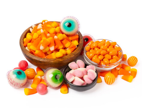 Halloween corn, jelly eyes, sugar skull and pumpkin candy isolated on white background. Classic sweet treats for Halloween. Halloween holiday concept with corn and jack o lantern.