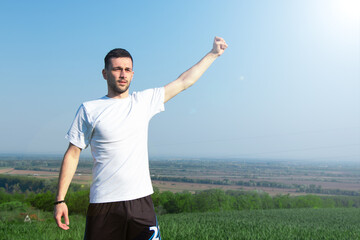 the athlete on the top of the hill raises his hand up, achieving the goal, success and freedom
