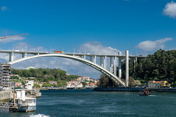 Fototapeta na wymiar Oporto, Portugal. April 13, 2022: Arrábida bridge and city landscape with blue sky.