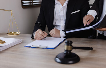 Close-up of asian lawyer and client discussing at office desk, law and justice concept. 