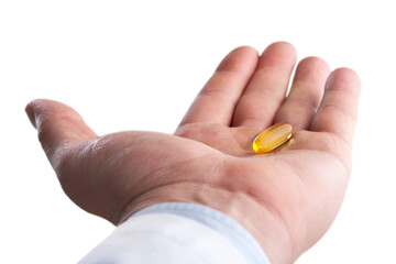 Fototapeta premium Fish oil pill in hand isolated on white
