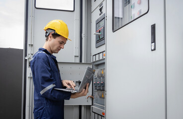 Electrical engineer working in control room. Electrical engineer man checking Power Distribution Cabinet in the control room