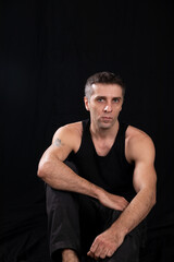 Fototapeta premium a man posing in a dark room on a black background