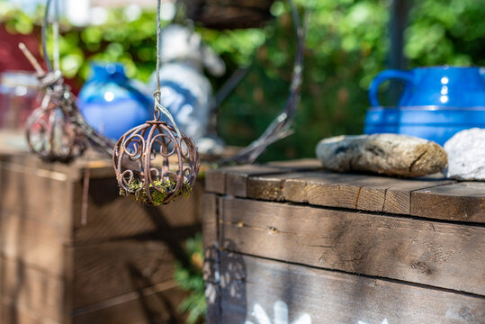 A rusted metal ball with moss as a garden decoration with wooden exterior