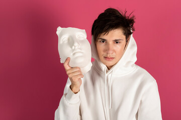 Portrait of a Suspicious young man in white hoodie covering face with a mask. Secret admirer,...