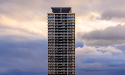 Dramatic sunset sky and tall residential tower with roof helipad - 597522223