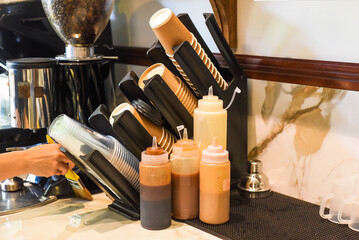 Many cups for take away drinks and ice cream with sweet syrups in a coffee shop
