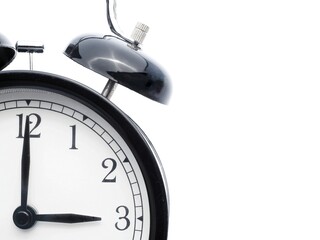 Black retro alarm clock at 3 o clock on a white background with copy space to add text