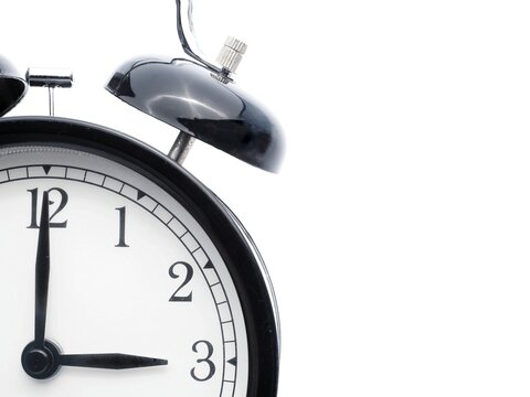 Black retro alarm clock at 3 o clock on a white background with copy space to add text
