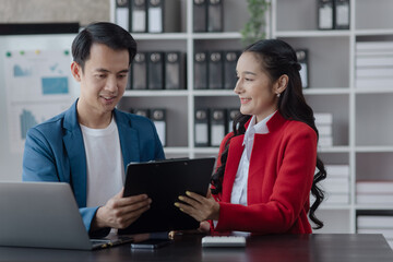 Two employees working at table in a modern office, Asian man and a woman work at office desk, Business campaign result and project planning concept.  