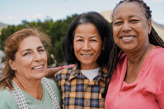 Happy multiracial elderly friends smiling in front of camera - Portrait of senior women outdoor
