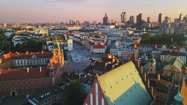 aerial view drone of warsaw city old town at sunset dusk,flying over castle square with modern downtown in the background
