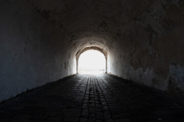 Perspective view of an empty tunnel with glowing end