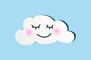 Sleeping cloud with a funny face on a blue background. The concept of a healthy child's sleep. Flat plan, top view, copying space.