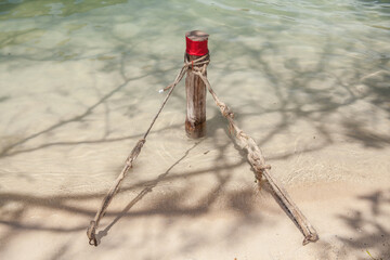 Fototapeta na wymiar Coton rope tied on wooden pole by the sea and beach
