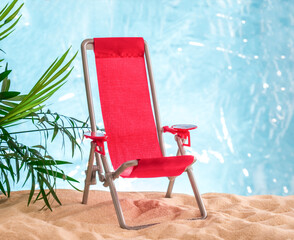 Pink beach chair on a sandy beach background.