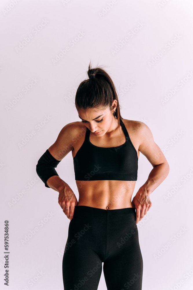 Poster Young female athlete training in a gym using sport equipment. Fit woman working out . Concept about fitness, wellness and sport preparation.