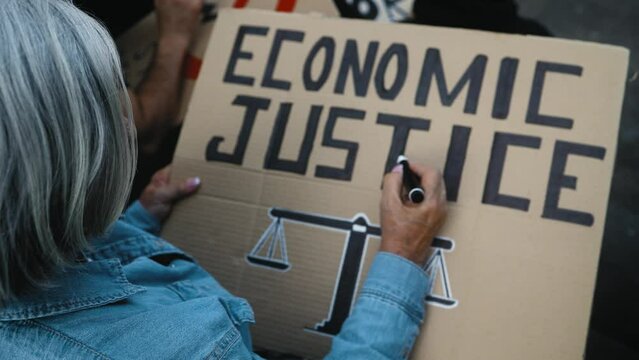 Senior activist make protest banners against financial crisis - Economic justice activism concept