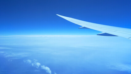 Fototapeta na wymiar Stunning view of deep blue sky from airplane window high above white clouds