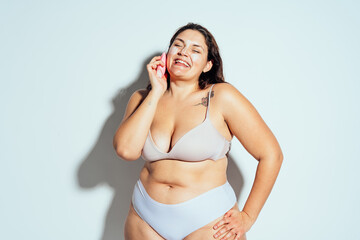 Plus size woman posing in studio in lingerie