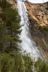 Fototapeta na wymiar Paisaje con la cascada de el Salt en Alcoy con pinos en primer plano. España