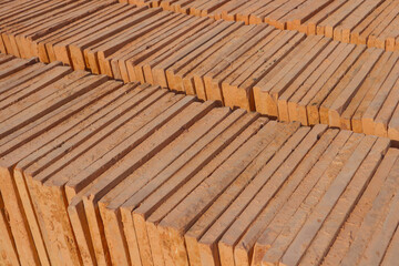 Abstract industrial background. Ceramic orange tiles are folded vertically with an edge.