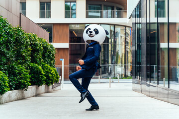 Storytelling image of a business man wearing a giant panda head