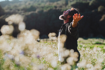 One man opening arms and love nature park standing in the middle of a white blossom flowers outstretching arm and enjoying freedom and happiness emotion. Mindful and travel destination people outdoor