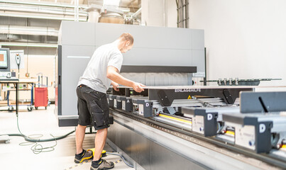 CNC Fräser legt die zu bearbeitende Platte in das CNC-Bearbeitungszentrum