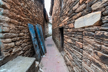 A narrow alley passing throughold traditional stone houses in the Himalayan town of Bageshwar in Uttarakhand.