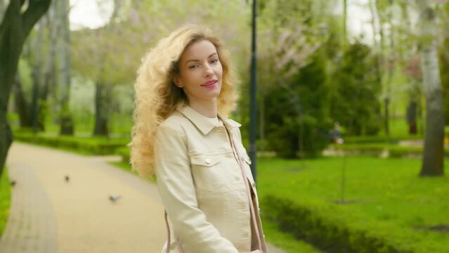 Rest, outdoor and joyful woman walking having fun smiling in park for health, peace, taking relaxing deep breath outside. Carefree stylish female lady in nature, fresh air for balance and energy.
