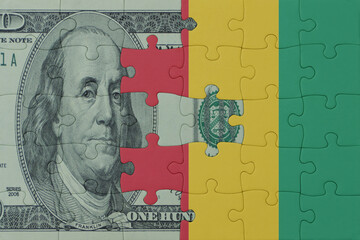 puzzle with the national flag of guinea and dollar money banknote. macro.concept.