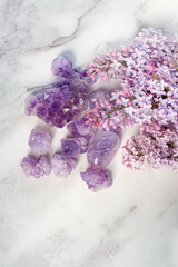amethyst minerals set and lilac flowers on abstract marble background. gemstones for esoteric...