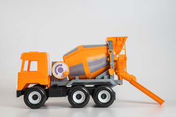 Multi-colored plastic children's toy cars on a white background. Orange concrete truck.