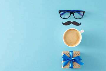 Father's Day celebration concept. Top view flat lay of stylish glasses black paper mustache cup of coffee and gift box on light blue background with empty space for greeting message - Powered by Adobe