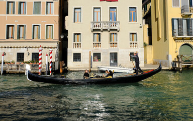 Fototapeta na wymiar Gondola navigating through canal in Venice, Italy