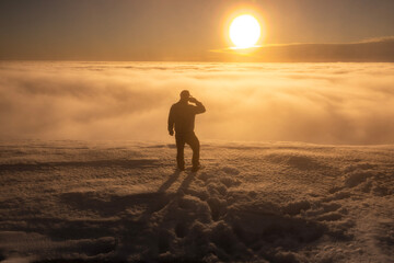 silhouette of a person with mobille in the mountains