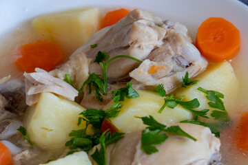 Boiled chicken thigh with potatoes and carrots. Chicken soup .