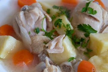 Boiled chicken thigh with potatoes and carrots. Chicken soup .