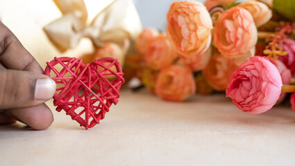 Valentines day concept image, Hand holding Red heart shape and small flowers bouquet on he background