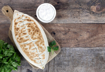 Qutab with green on wooden background. Azerbaijani flat bread with greens. Top view, copy space. Azerbaijani, armenian food. 