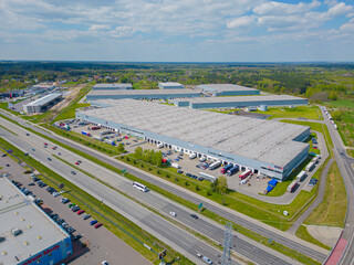 Aerial view of the logistics park with warehouse, loading hub and many semi trucks with cargo...