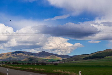 Panoramic landscape with snowy mountains and dramatic clouds