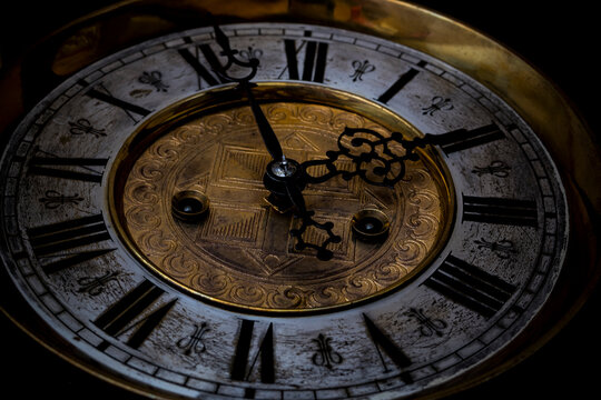 Old wooden clock with a pendulum hanging on the wall © Alexander Odessa 