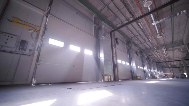 Construction process of a big, modern warehouse with multiple garage gates for easy access and transportation of goods.