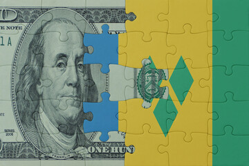puzzle with the national flag of saint vincent and the grenadines and dollar money banknote. macro.concept.