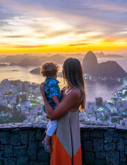 Mother and son tourists at the Dona Marta lookout overlooking the Sugar Loaf Mountain