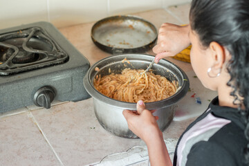 closeup of a latin brunette girl learning to prepare spaghetti