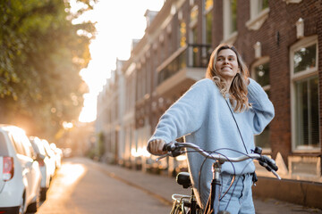 Pretty young woman on bicycle in the city street, city transportation. Outdoor fashion portrait of...
