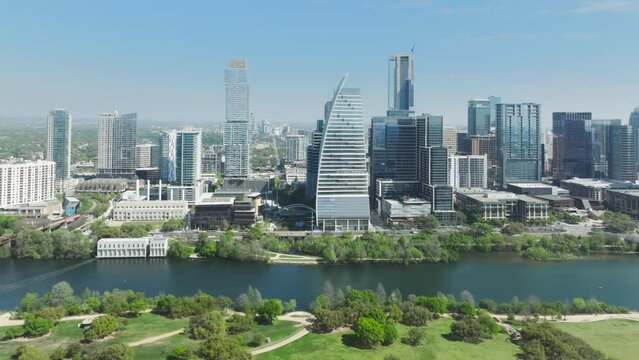 Downtown Austin at sunny summer day. Scenic Austin skyline panorama. Aerial view of downtown, Beautiful urban landscape of green scenic Texas city. Business city tall buildings at Colorado river 4K